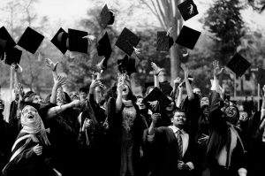 group of seniors toss caps at graduation gala facility